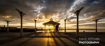 Joggers on dun Laoghaire Pier at Sunset